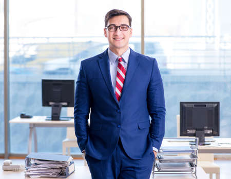 Young handsome businessman employee working in office at desk