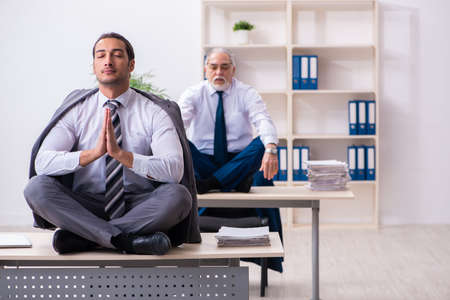 Two male employees working in the officeの写真素材