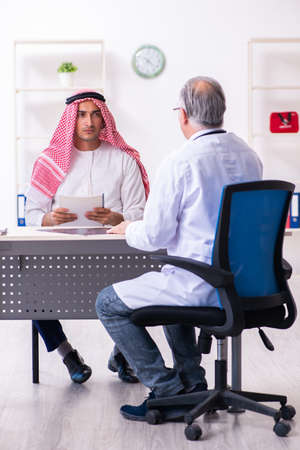 Young male arab visiting experienced male doctorの写真素材
