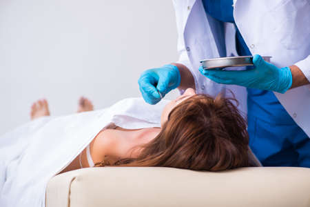 Police coroner examining dead body corpse in morgueの写真素材