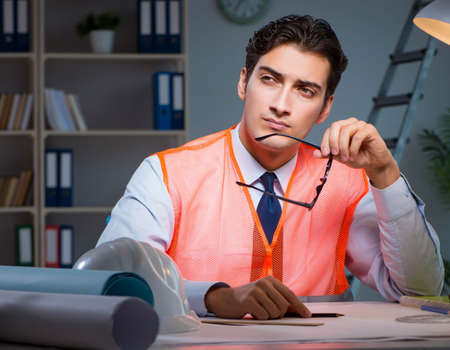 Construction architect working on drawings late at night