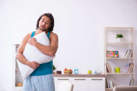 Young man waking up at homeの写真素材