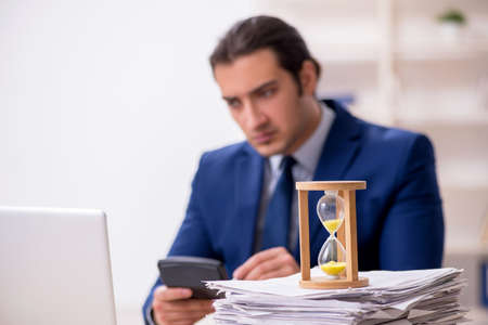 Young male employee in time management concept