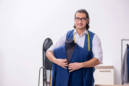 Young male tailor working at workshopの写真素材