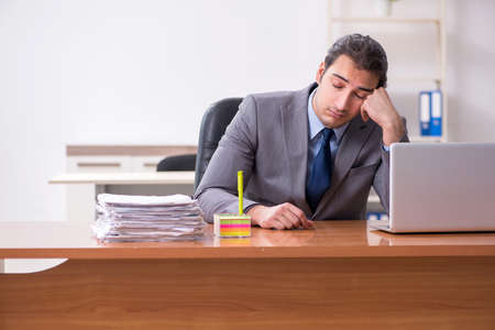 Young male employee sleeping in the officeの写真素材