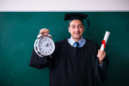 Young male graduate in front of boardの写真素材