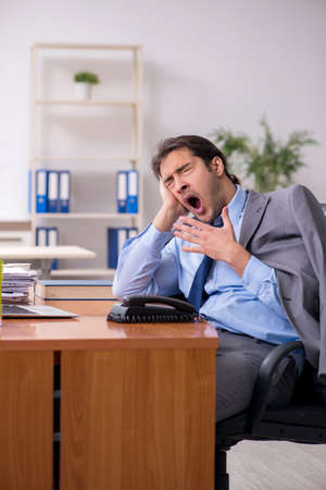 Young male employee sleeping in the officeの写真素材