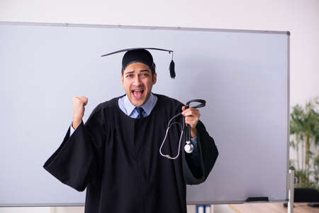 Young male graduate in front of boardの写真素材