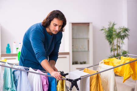 Young man husband doing clothing ironing at homeの写真素材