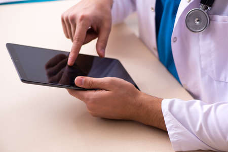 Young male doctor in telemedicine conceptの写真素材