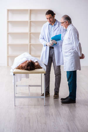 Police coroner examining dead body corpse in morgueの写真素材