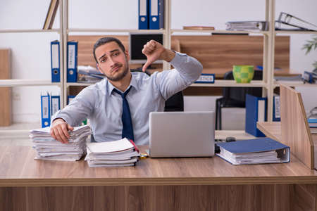 Young male employee unhappy with excessive workの写真素材