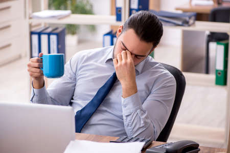 Young male employee unhappy with excessive workの写真素材