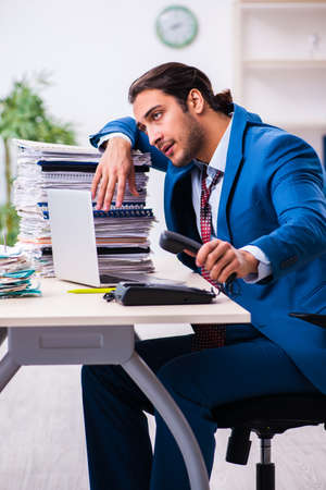 Young male employee unhappy with excessive workの写真素材