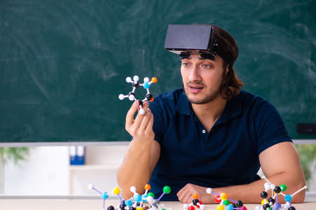 Young male scientist sitting in the classroom