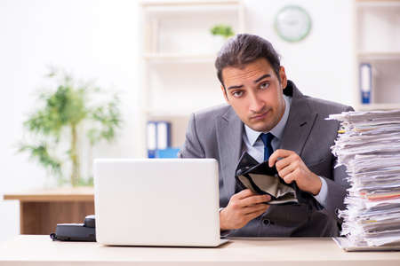 Young male businessman unhappy with excessive workの写真素材