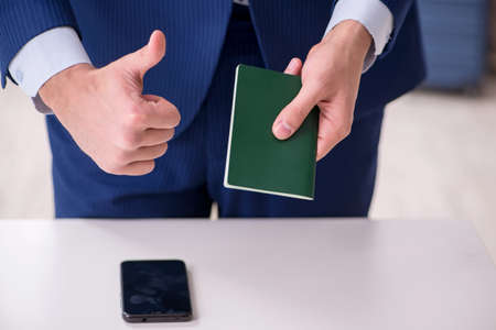 Young businessman holding passport preparing for tripの写真素材