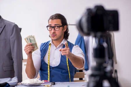Young male tailor recording video for his blog