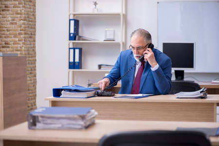 Old male boss employee working in the officeの写真素材