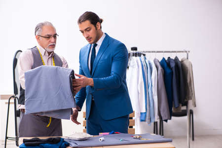 Young businessman visiting old male tailorの写真素材