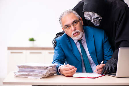 Old businessman employee getting deal with the devilの写真素材