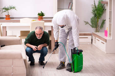 Young male sanitizer and old man indoorsの写真素材