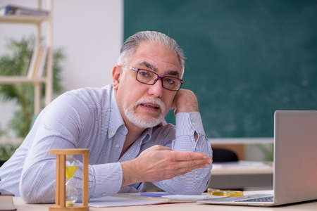 Old male teacher in the classroomの写真素材
