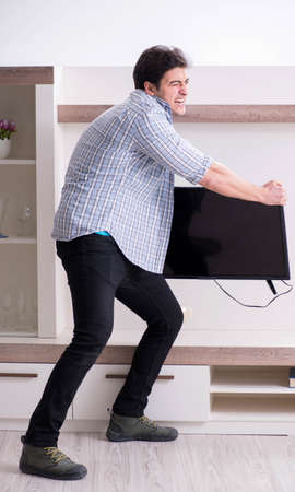 Man trying to fix broken tvの写真素材