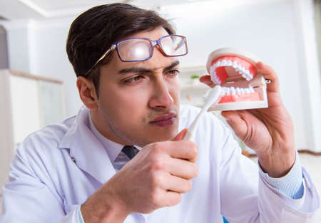 Funny dentist with toothbrush in medical conceptの写真素材
