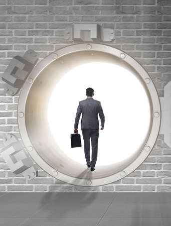 Businessman in front of banking vault doorの写真素材