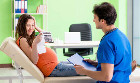 Pregnant woman visiting male gynecologyst at the clinic