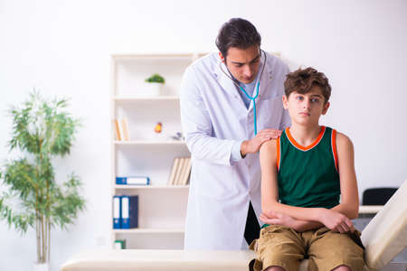 Sick boy visiting young male doctor pediatricianの写真素材