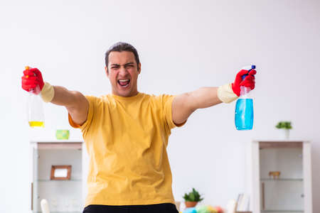 Young male contractor cleaning the house