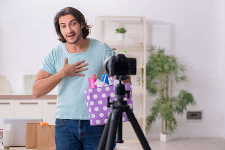 Young male shopaholic recording video for his blogの写真素材