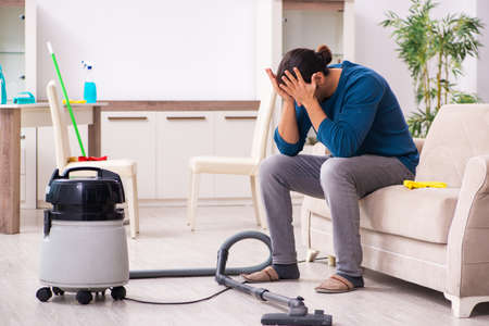 Young man husband doing housework at homeの写真素材