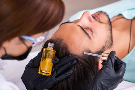 Young man visiting female beautician in hair transplantation con