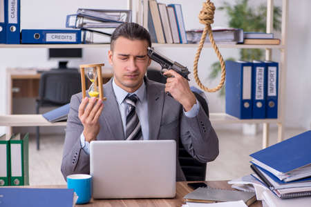 Young male employee committing suicide at workplaceの写真素材