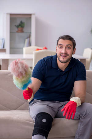 Young leg injured contractor cleaning the house