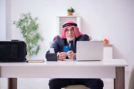 Old arab businessman preparing for business tripの写真素材