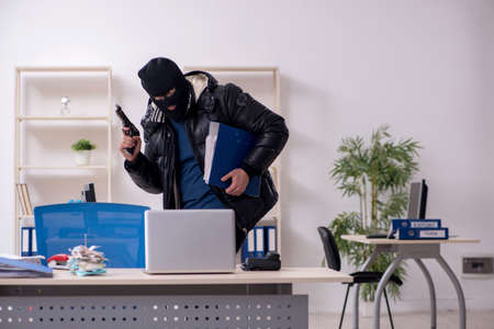 Young male burglar in the officeの写真素材