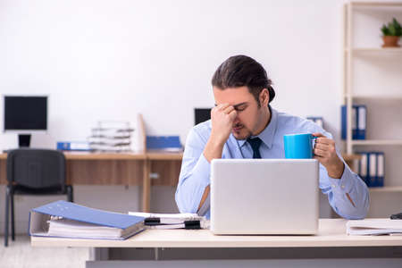 Sick male employee suffering at workplaceの写真素材