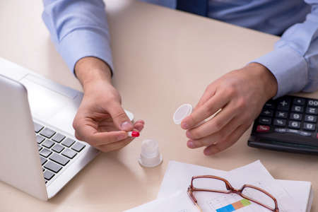 Sick male employee suffering at workplaceの写真素材