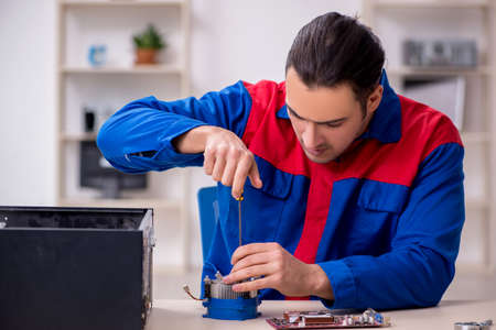 Young male repairman repairing computerの写真素材