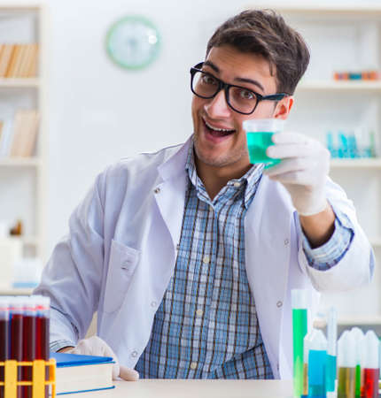 Young chemist student working in lab on chemicalsの写真素材