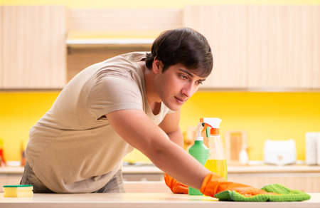 Single man cleaning kitchen at home