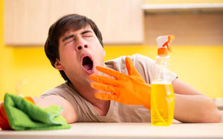 Single man cleaning kitchen at home