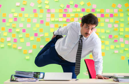 Man in the office with many conflicting priorities doing exercisの写真素材