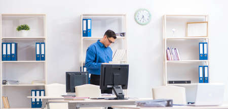 Handsome businessman employee sitting at his desk in officeの写真素材