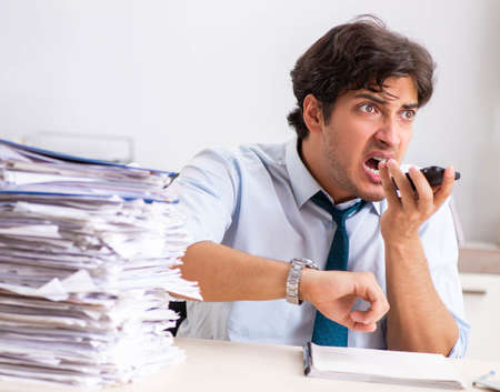 Overloaded busy employee with too much work and paperworkの写真素材