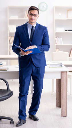 Young handsome businessman employee working in office at deskの写真素材
